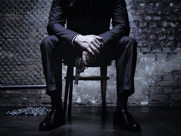 mann-mit-waffe-sitzt-auf-einem-stuhl-.jpg.f7c2c07d7c0f83784cdc98e27a8446c2.jpg